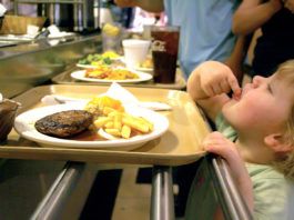 Lundy Grace, 2, sneaks a bite of her french fries in line at Piccadilly Wednesday night.