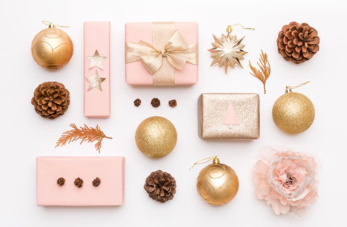 Pink and gold christmas gifts isolated on white background. Wrapped xmas boxes, christmas ornaments, baubles and pine cones. Christmas composition.
