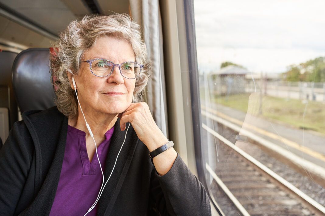 Smiling mature woman looking at the view through a train window