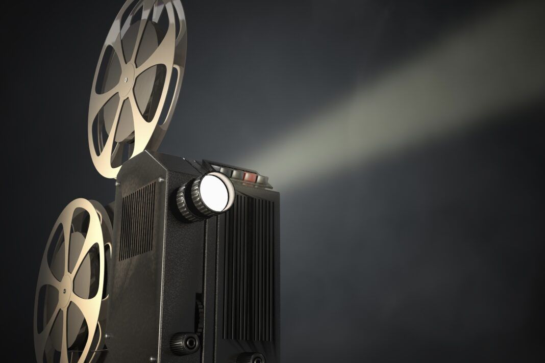 Retro movie projector on dark background. 3D rendered illustration.