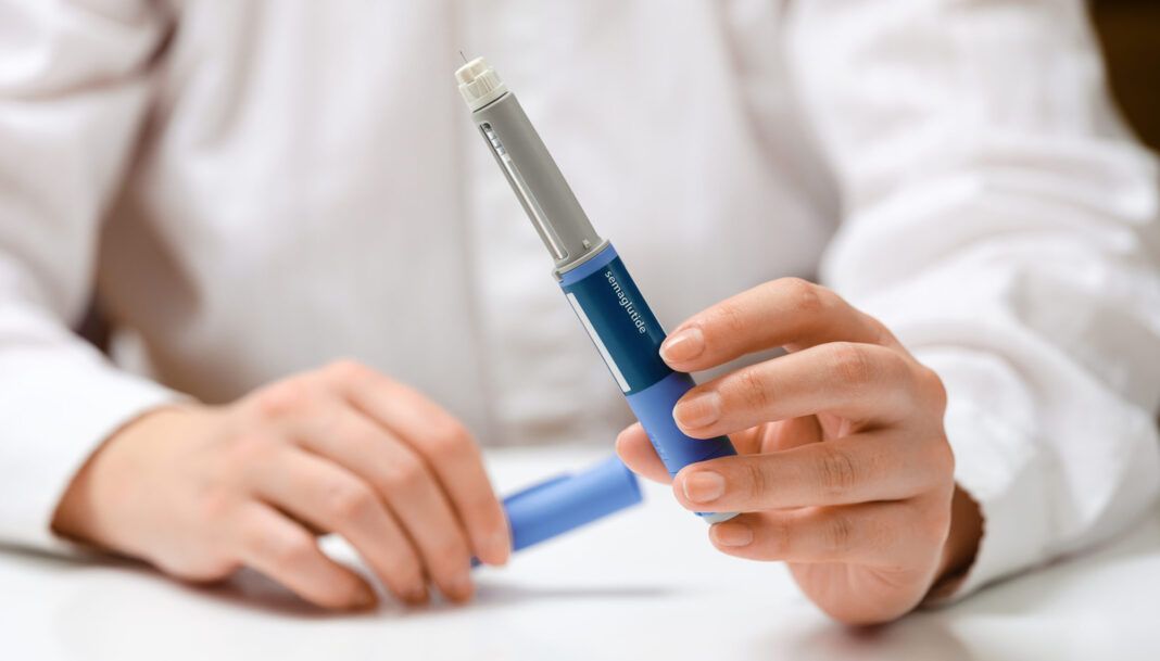 Female hands holding Semaglutide injection pen.